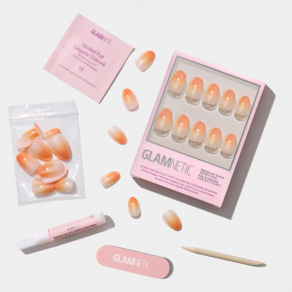 The glamnetic Candy Corn set features orange ombré nails with a peach fade, plus a nail file, cuticle stick, nail glue, alcohol pad, and extra nails—ideal for Halloween flair—all shown on a crisp white background. - Product image