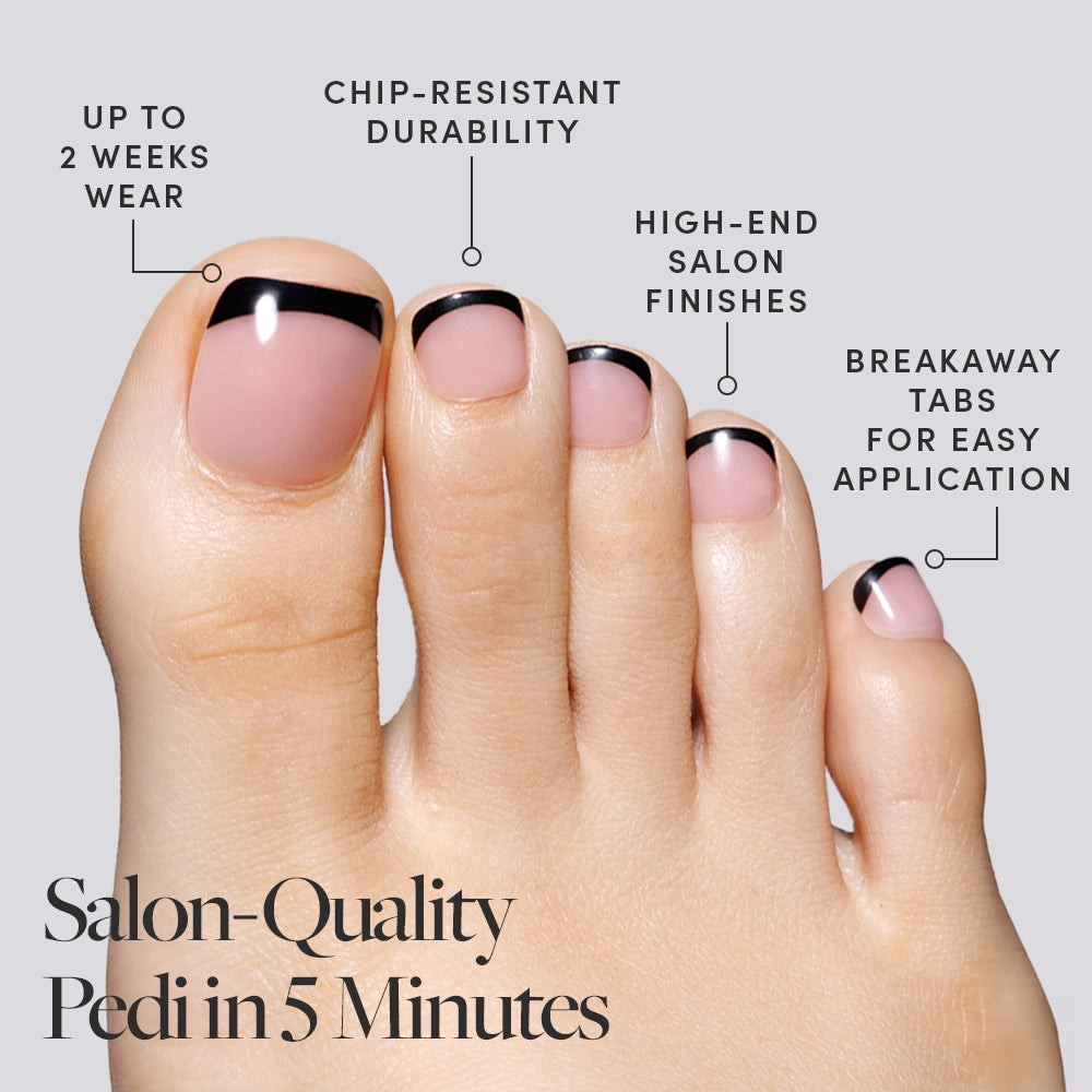 A foot in Glamnetic black French tip press-on toenails with labeled benefits including easy application and chip resistance. - Product image