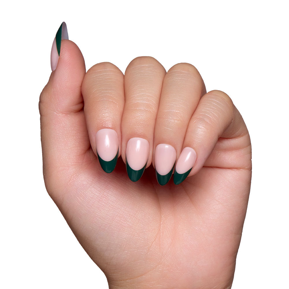 A hand with short almond nails features a dark green French tip, shown against a white background. The slightly clenched hand highlights the chic Château press-on nail set by glamnetic. - Product image