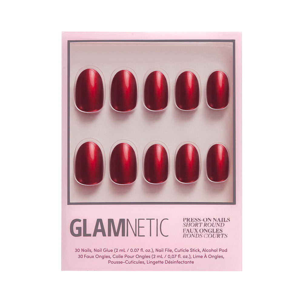 A pink Glamnetic box labeled Cherry Glaze holds 10 cherry-red, short round press-on nails in two rows with nail glue, file, cuticle stick, and alcohol pad included.