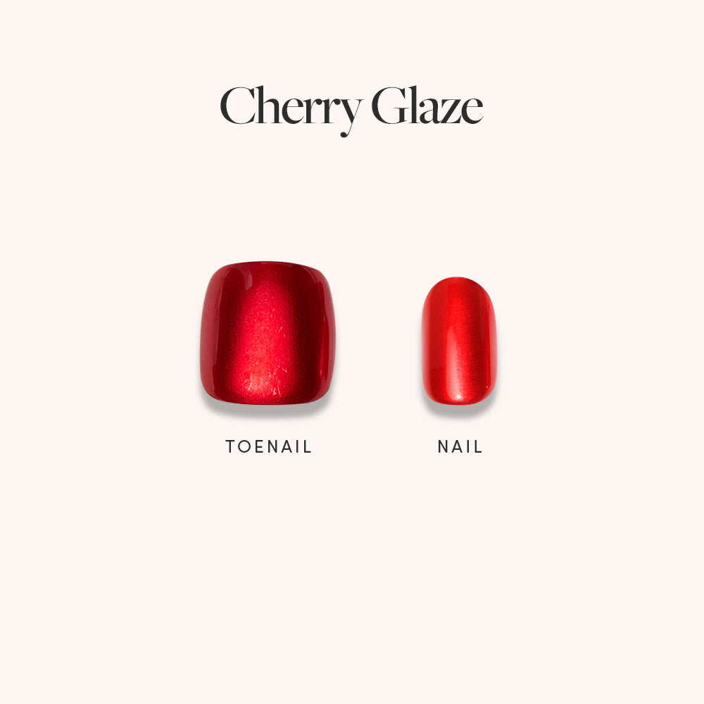 Glamnetic’s Cherry Glaze Mani Pedi set features two vibrant red artificial nails—a square toenail and an oval fingernail—shown on a light background, perfect for a juicy, matching manicure and pedicure look.