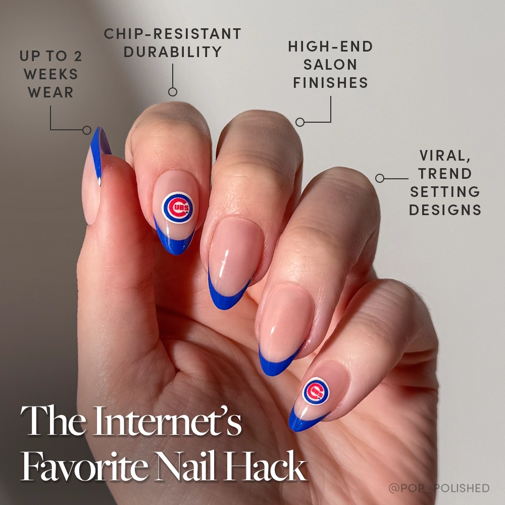 A hand with long, almond-shaped nails showcases blue French tips and Chicago Cubs logos. The glamnetic Chicago Cubs Press-On Nail Set offers chip-resistant durability, up to 2 weeks wear, high-end finishes, and on-trend designs. - Product image
