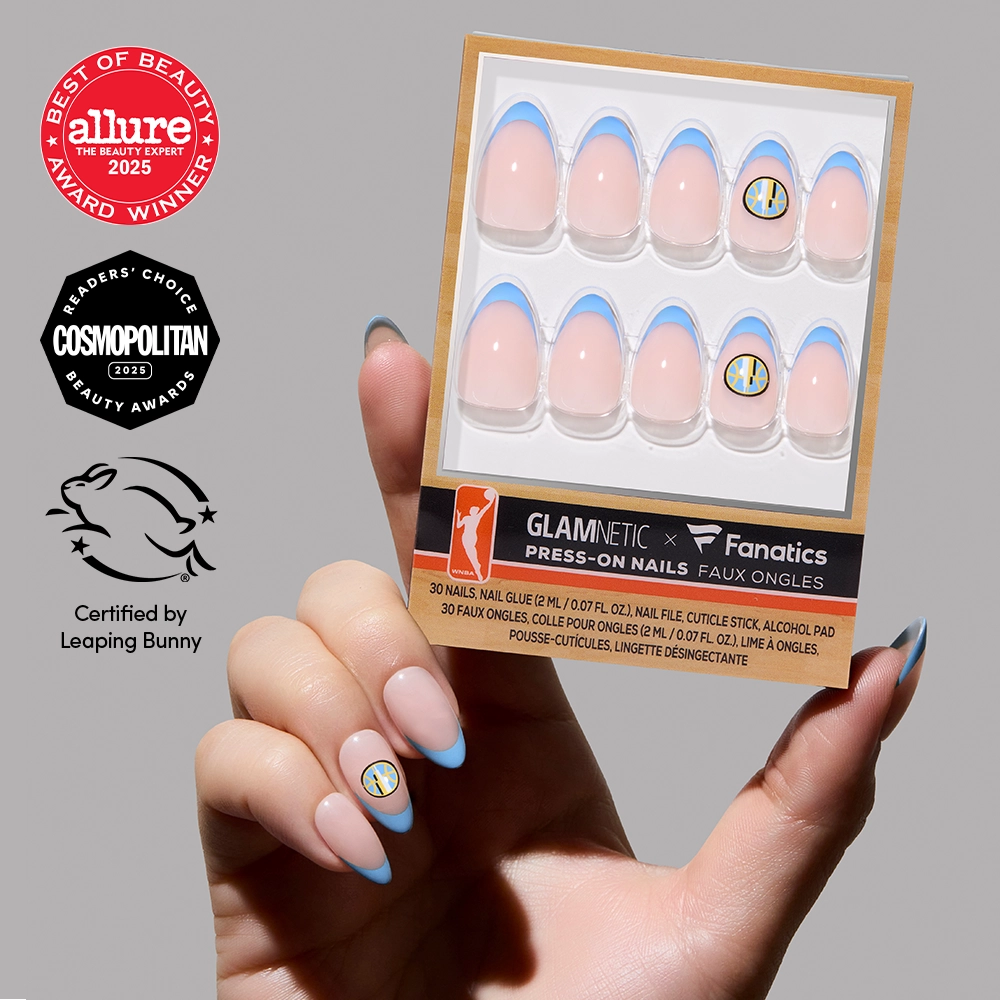 A hand with blue-tipped, salon-quality glamnetic Chicago Sky Press-On Nails holds the officially licensed set. Allure, Cosmopolitan, and Leaping Bunny certification logos are also featured in the image.
