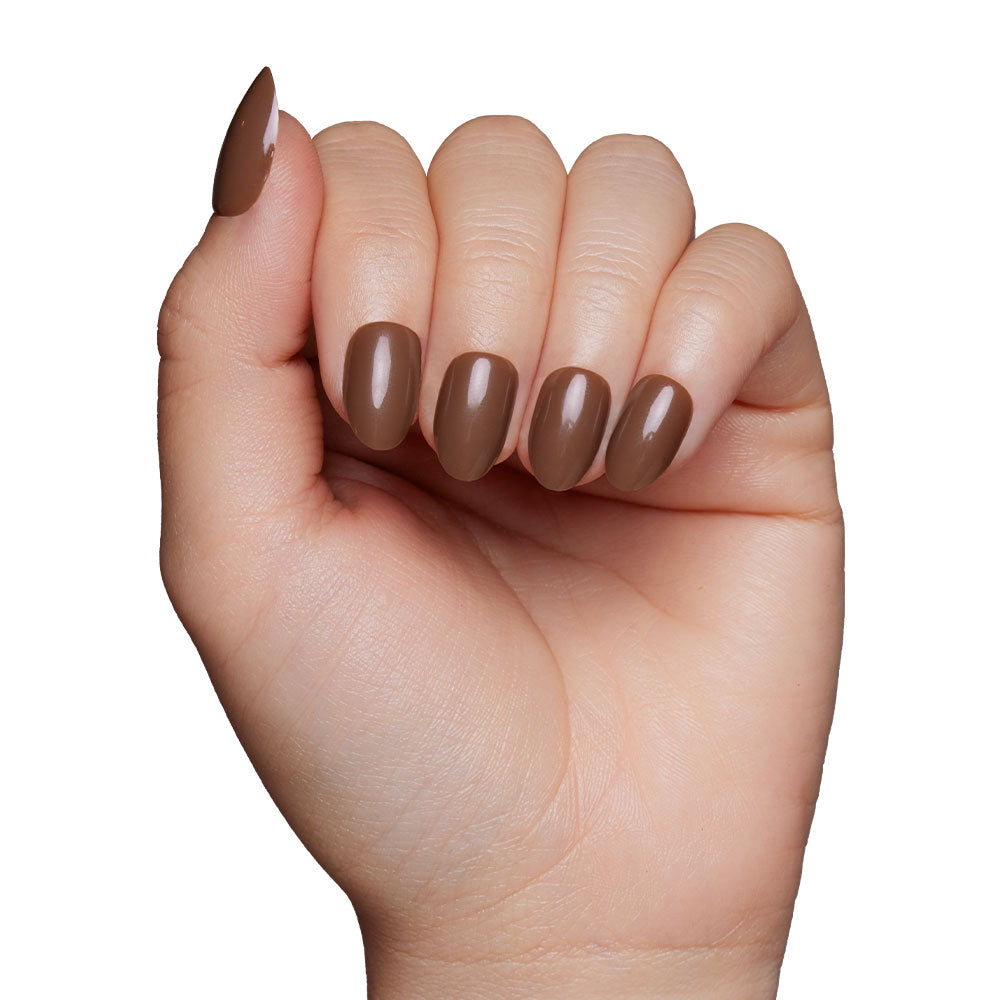 A hand with fingers curled inward displays neatly manicured glamnetic Press-On Nails in the shade Chocolate Brown, set against a plain white background. - Product image