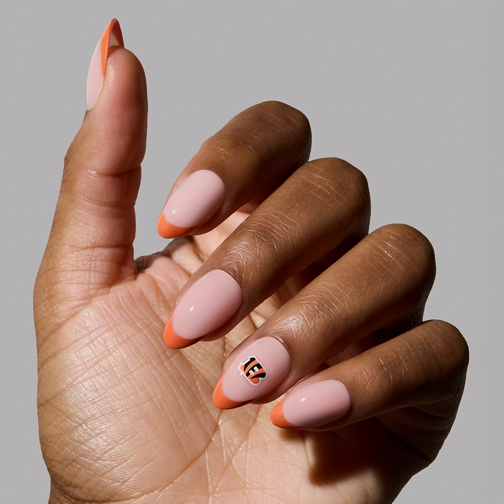 Show your team spirit with the glamnetic Cincinnati Bengals Press-On Nail Set, featuring almond-shaped pink nails with orange French tips and a tiger-inspired striped accent—perfect for game day!. - Product image