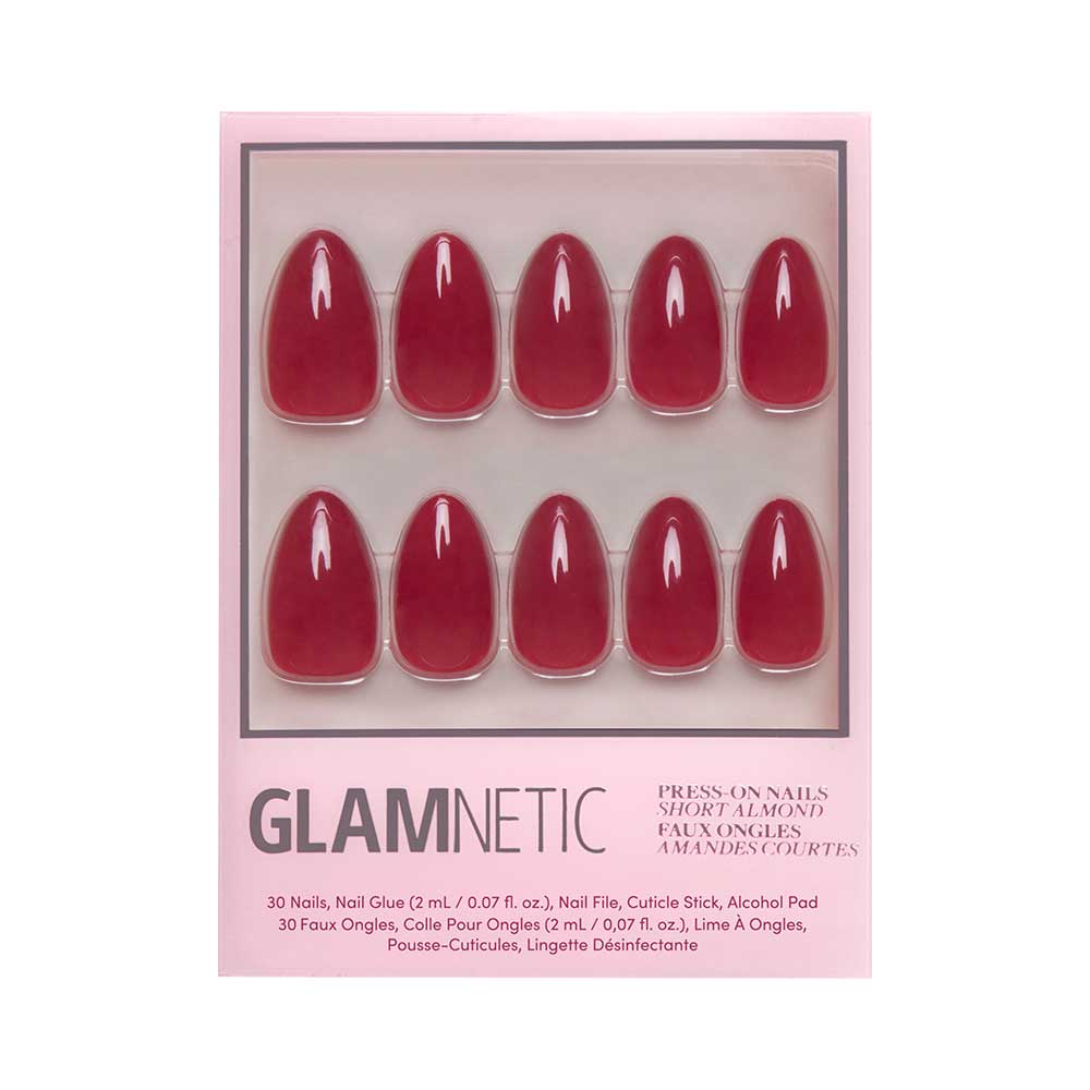 A box of glamnetic Classic Red press-on nails in glossy almond shape, arranged in two rows. The package contains 30 nails, nail glue, a nail file, a cuticle stick, and an alcohol pad.