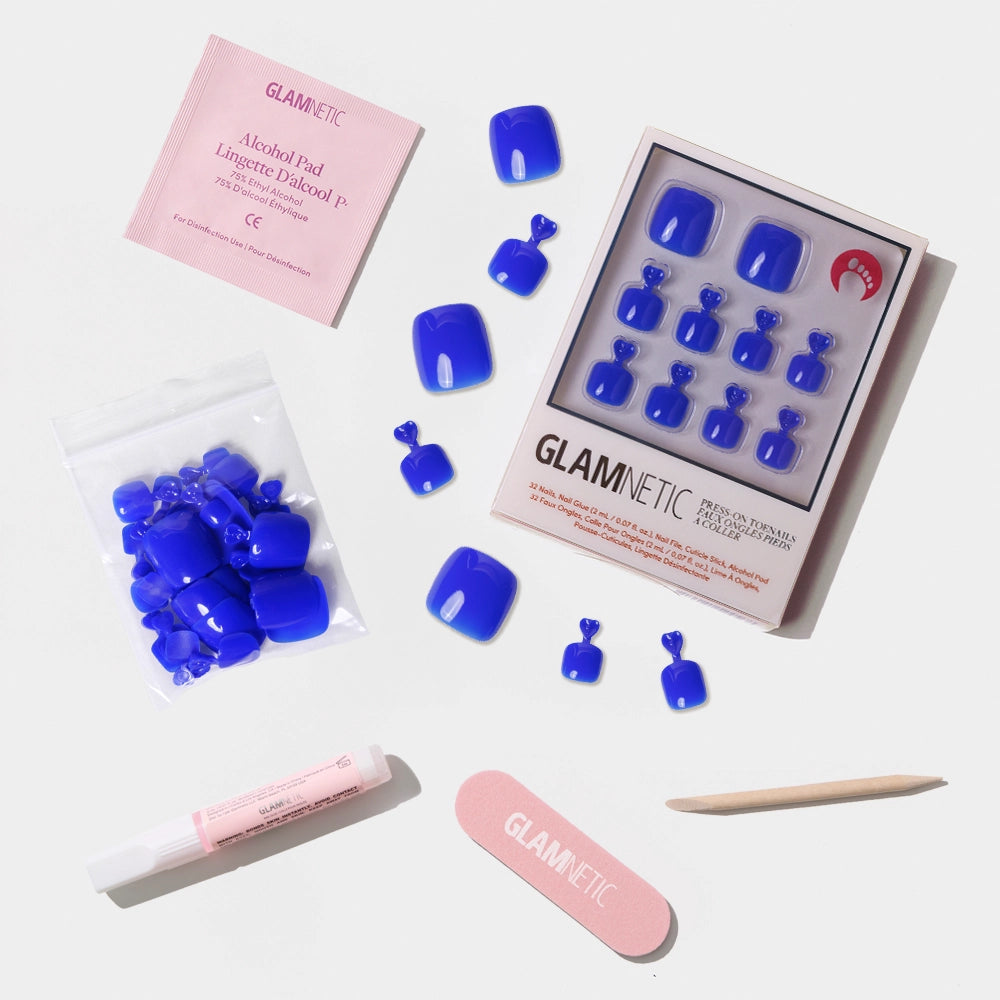 A flat-lay of the Glamnetic bright cobalt blue press-on toenail kit with all included application tools. - Product image