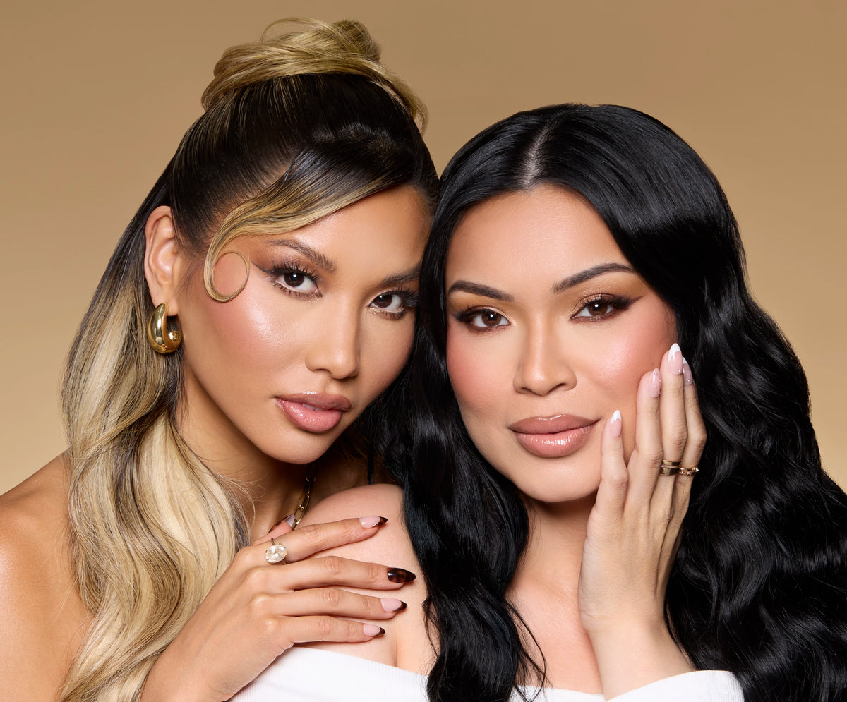 Glamnetic founder Ann McFerran and influencer Glamzilla pose together against a soft beige background, showcasing their manicured nails—Ann with a white French tip look and Glamzilla with a deep brown tortoiseshell design. Both wear glam makeup and statement rings, radiating elegance and confidence.