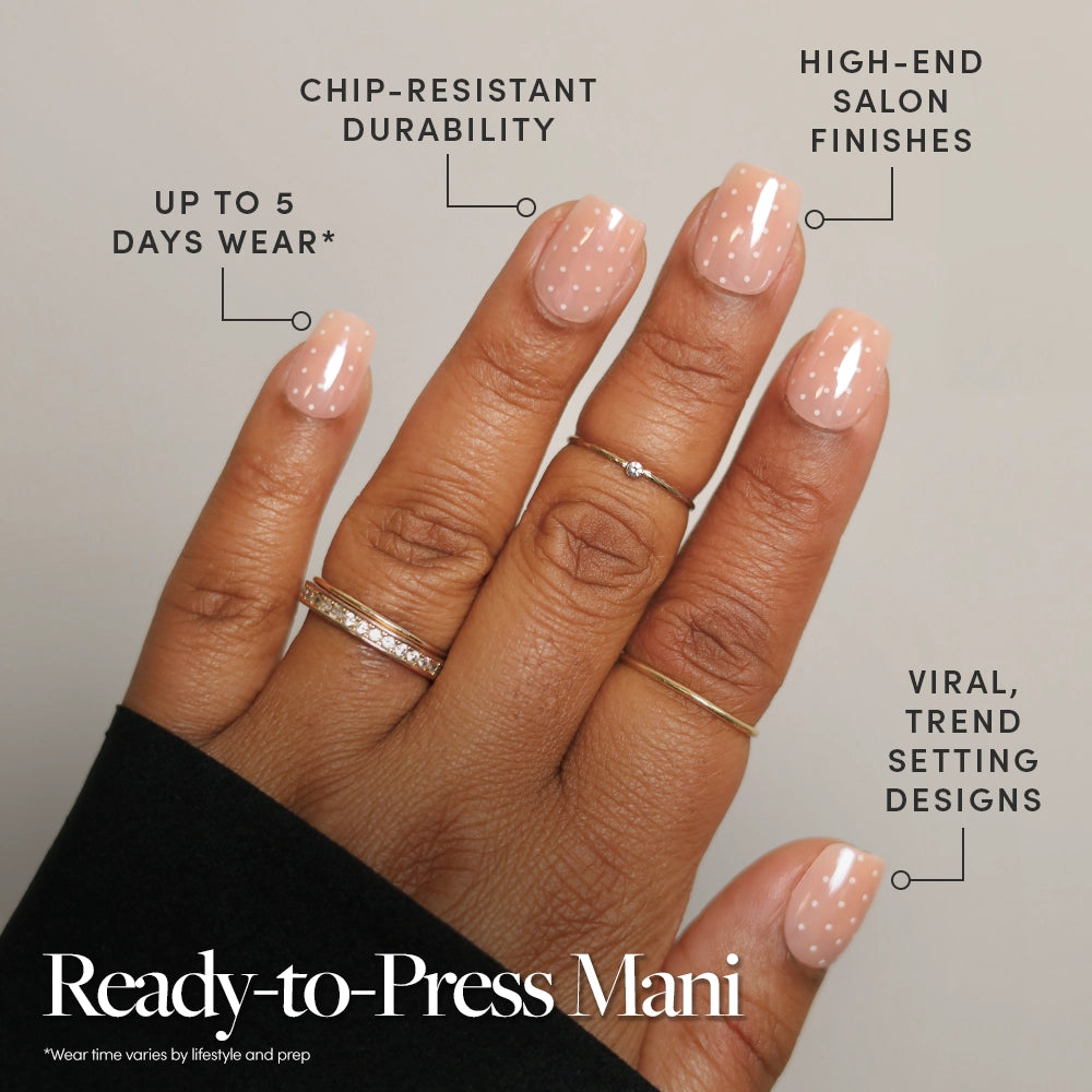 A hand with light pink, polka-dot glamnetic Dainty Dots press-on nails is shown—chip-resistant, salon-quality, trendy, and lasts up to 2 weeks. Text: Ready-to-Press Mani—your quick way to flawless style in minutes. - Product image