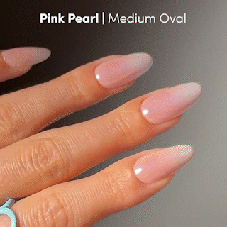 A hand with medium oval-shaped nails from glamnetic, painted in a glossy Pink Pearl shade, is shown up close. The salon-quality press-on nails are paired with a turquoise ring on the finger. Text reads: Pink Pearl | Medium Oval.