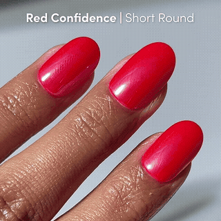 Close-up of three fingers with short, rounded nails painted in Runway Red by glamnetic for a salon-quality manicure. Text at the top reads “Runway Red | Short Round.”.