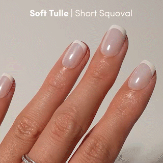 A hand with short, square-oval (squoval) nails features a soft, natural pink base and crisp white French tips. This elegant look highlights the glamnetic Soft Tulle Press-On Nails in a refined short squoval shape. The text Soft Tulle | Short Squoval is displayed at the top of the image. - Product image