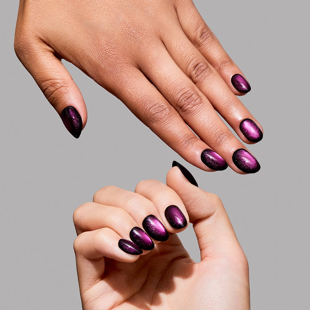 Two hands with manicured, short oval nails are shown against a plain gray background, featuring glamnetic’s Dark Romance polish—a glossy, dark purple and pink gradient. - Product image