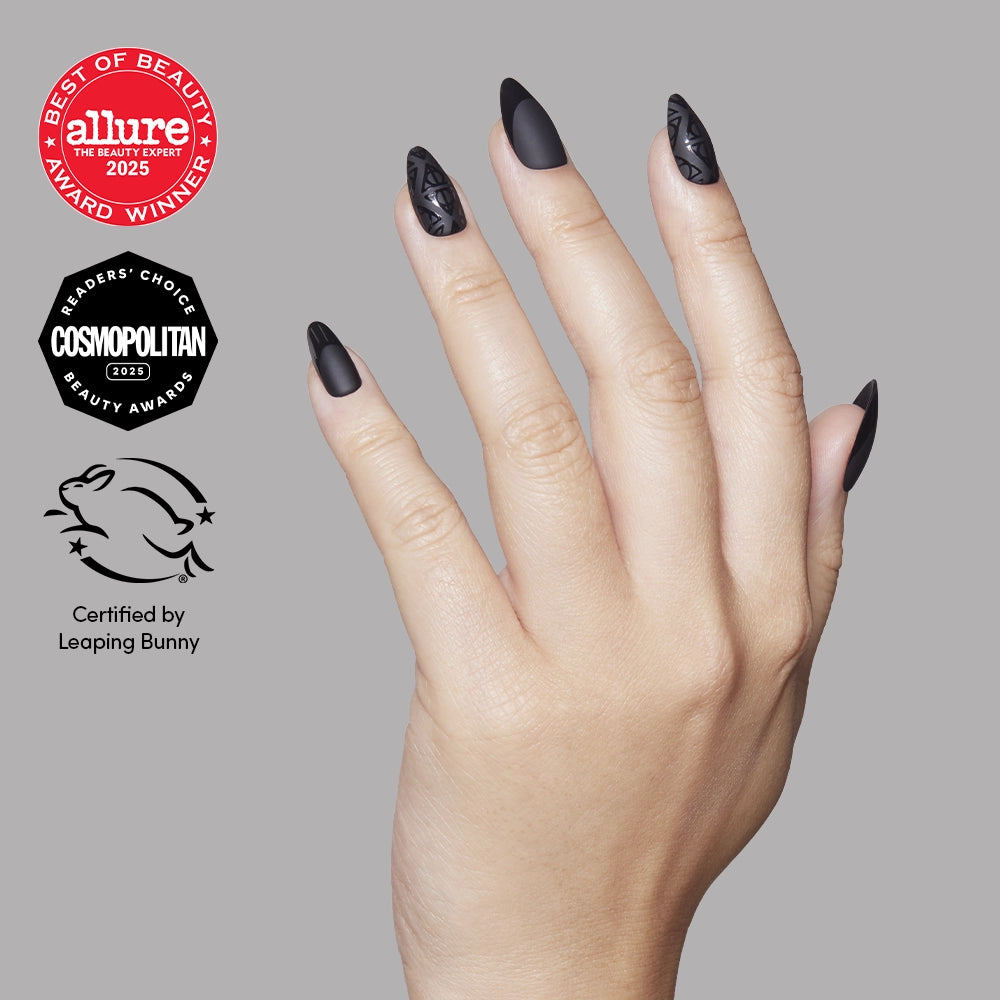 A hand displays Deathly Hallows™ almond-shaped matte black press-on nails with geometric patterns, alongside Allure Best of Beauty, Cosmopolitan Readers Choice, and Leaping Bunny cruelty-free certification seals.