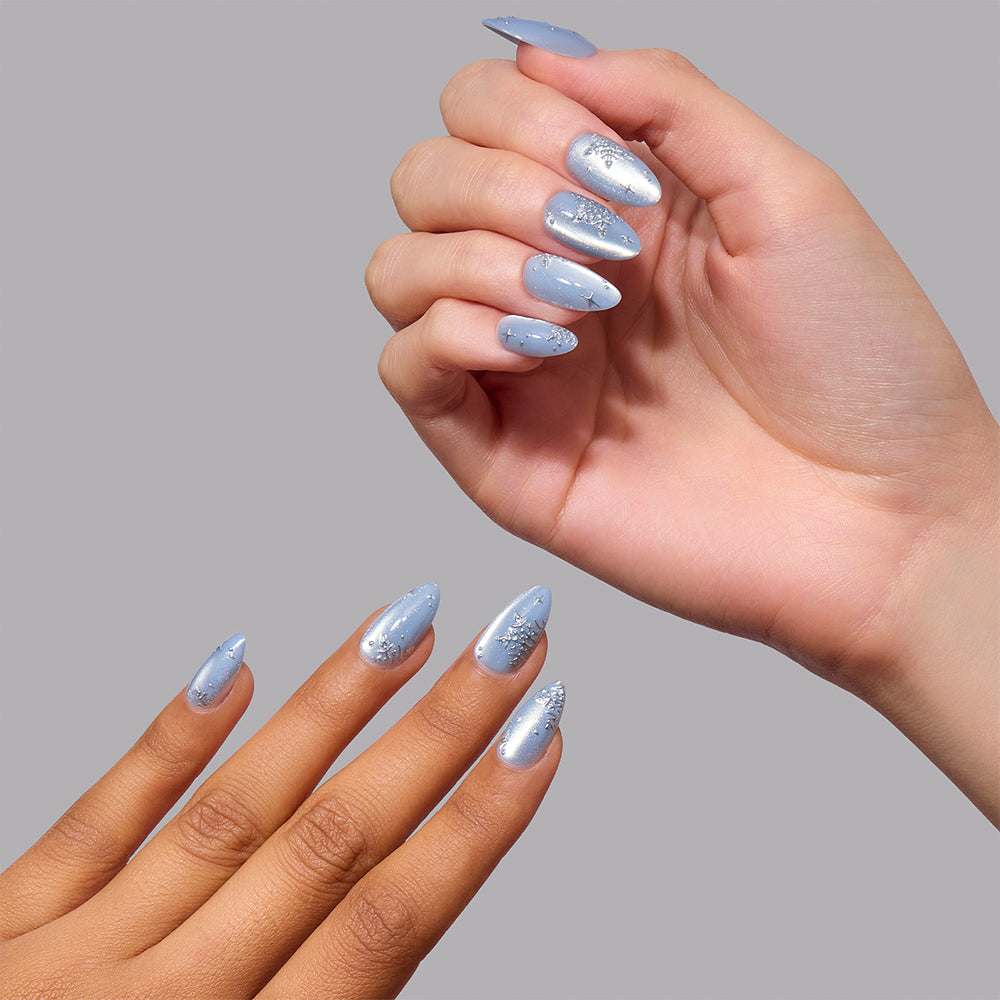 Glamnetic December Sky short almond press-on nails in a shimmery light blue velvet effect finish, accented with silver snowflake and star designs. - Product image
