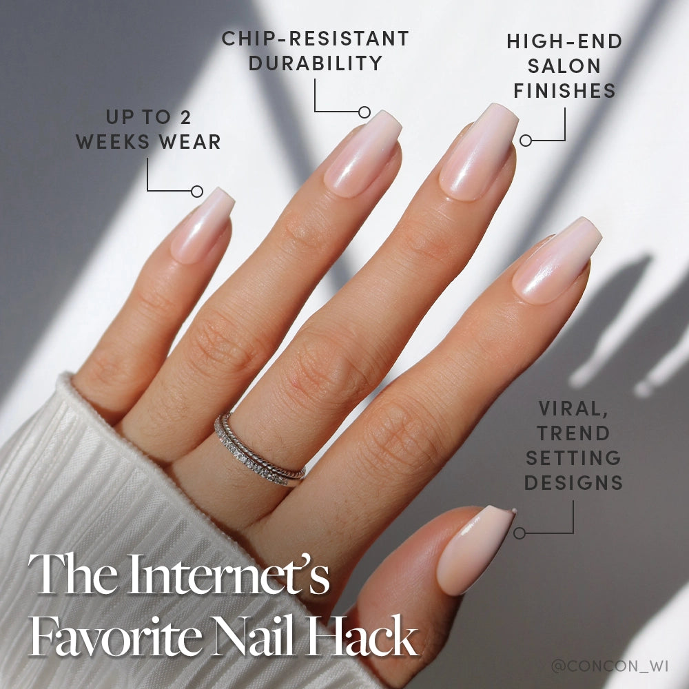 A hand with long, light pink coffin-shaped glamnetic Delicate Touch press-on nails is shown, offering durability, a high-end finish, and trendy style. The person wears a white sweater and two silver rings. Text: The Internet’s Favorite Nail Hack—Press-Ons made easy. - Product image