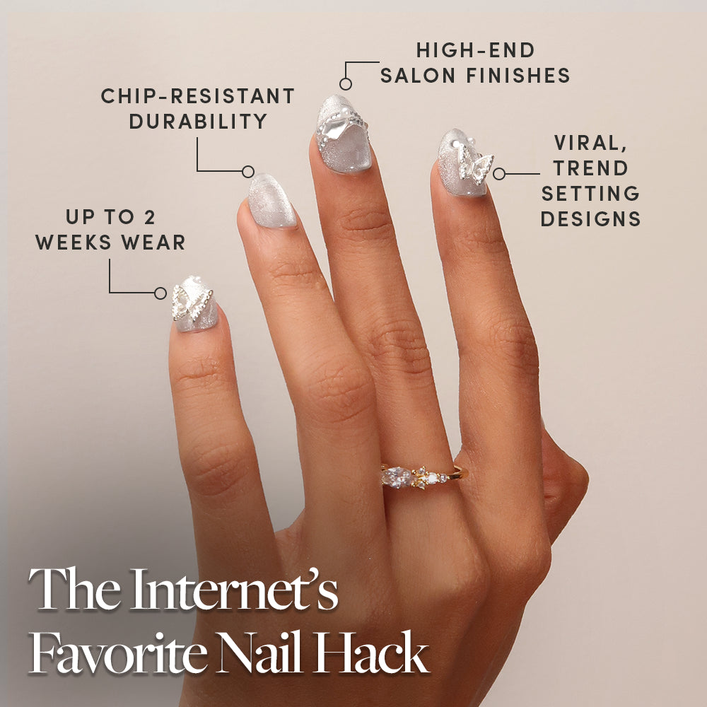 A hand with glamnetic Diamond Press-On Nails in silver is displayed, showcasing chip-resistant durability, high-end salon finishes, up to 2 weeks of wear, and viral trendy designs. The short oval nails feature striking 3D nail art. Title: The Internet’s Favorite Nail Hack. - Product image