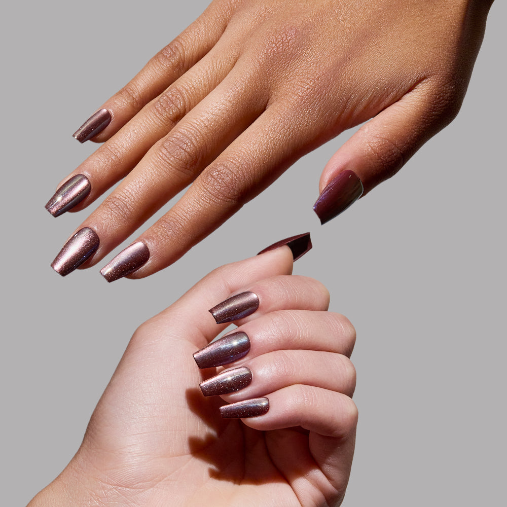 Two hands with manicured medium coffin nails painted in glamnetic's Espresso Glow are positioned against a plain grey background, showing off the shiny, reflective finish of this metallic mauve nail color. - Product image