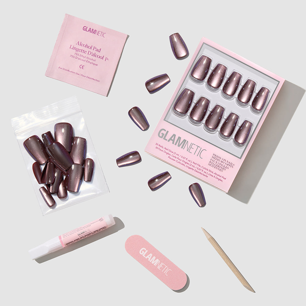 Espresso Glow by glamnetic features mauve velvet shimmer nails in a medium coffin shape, plus an alcohol pad, glue, cuticle stick, nail file, and extra nails—neatly displayed on a light background with branded packaging. - Product image