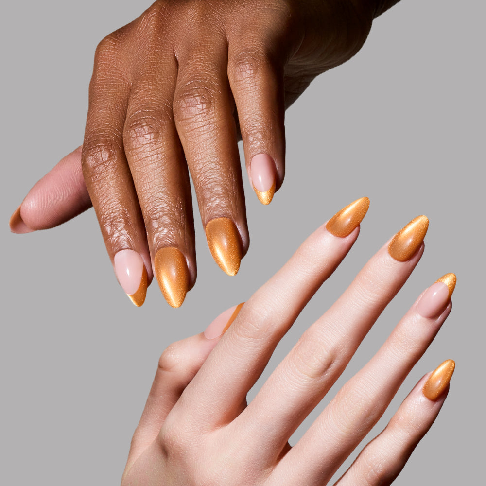 Two hands with manicured nails are shown against a plain gray background. glamnetic’s Orange Pop short almond press-on nails feature a vibrant orange polish with a glossy finish, delivering salon-quality style for any skin tone. - Product image