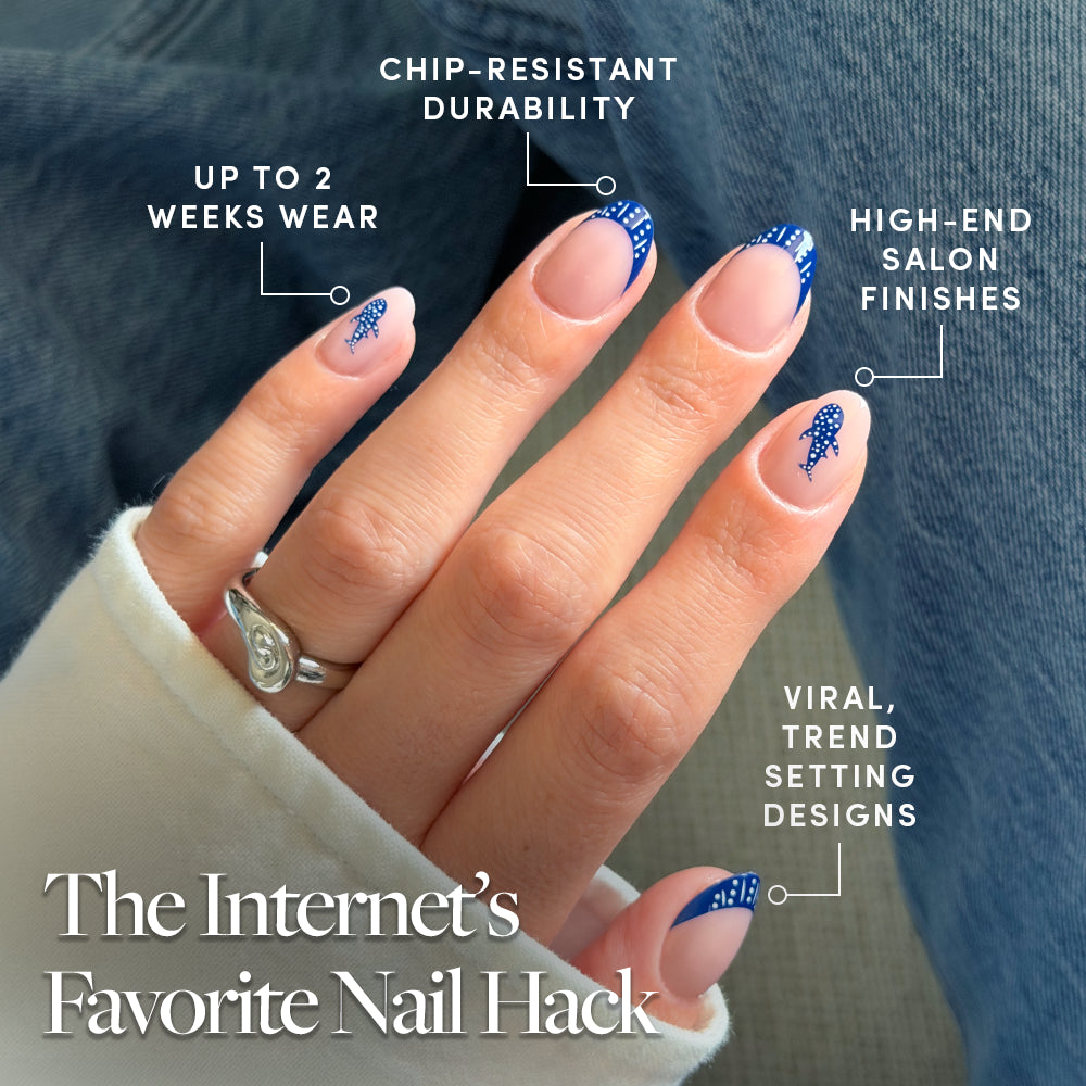 A hand with medium-length almond nails features glamnetic's Whale Waves: blue and white trendy nail art with dark blue French tips. Enjoy up to 2 weeks wear, chip-resistant durability, salon-quality finish, and viral designs. - Product image