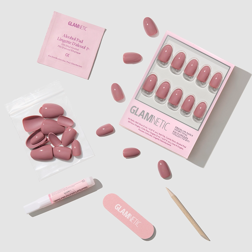 The Fall Mauve Nail Set by glamnetic features pink press-on nails with trendy fall designs, plus a nail file, cuticle stick, alcohol pad, nail glue, and extra nails—all neatly displayed on a light gray background. - Product image