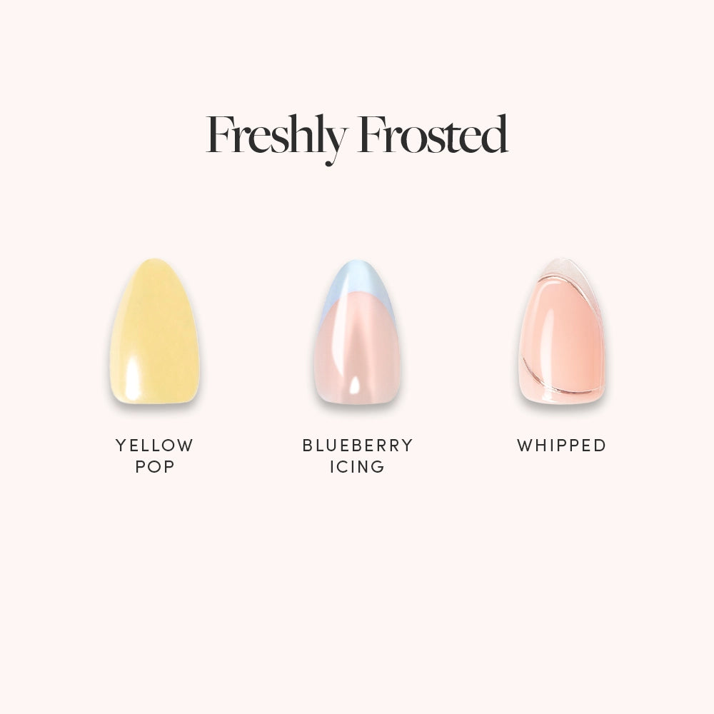 Three glamnetic artificial nails, named Freshly Frosted, pop against a light background. This short almond set features Yellow Pop, Blueberry Icing, and Whipped shades with playful silver chrome swirls beneath each name.