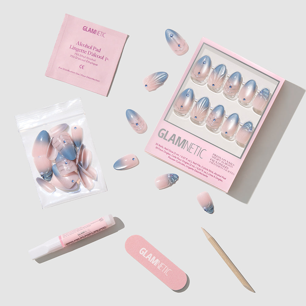 Frosted Crystals - Glamnetic Frosted Crystals press-on nails featuring a blue-to-nude ombre design with rhinestone accents, arranged in a box with a nail file, glue, cuticle stick, and alcohol pad.