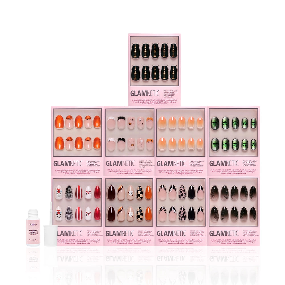 Nine boxes of glamnetic Funhouse Fantasy press-on nails, featuring spooky and vibrant pumpkin designs, are stacked in a pyramid. A small nail glue bottle sits in front on a white background. - Product image