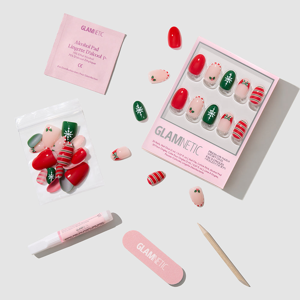 Gifting Season - Glamnetic Gifting Season press-on nails in a short oval shape with red, green, and cream designs, including adhesive, an alcohol prep pad, nail glue, a nail file, and a cuticle stick.