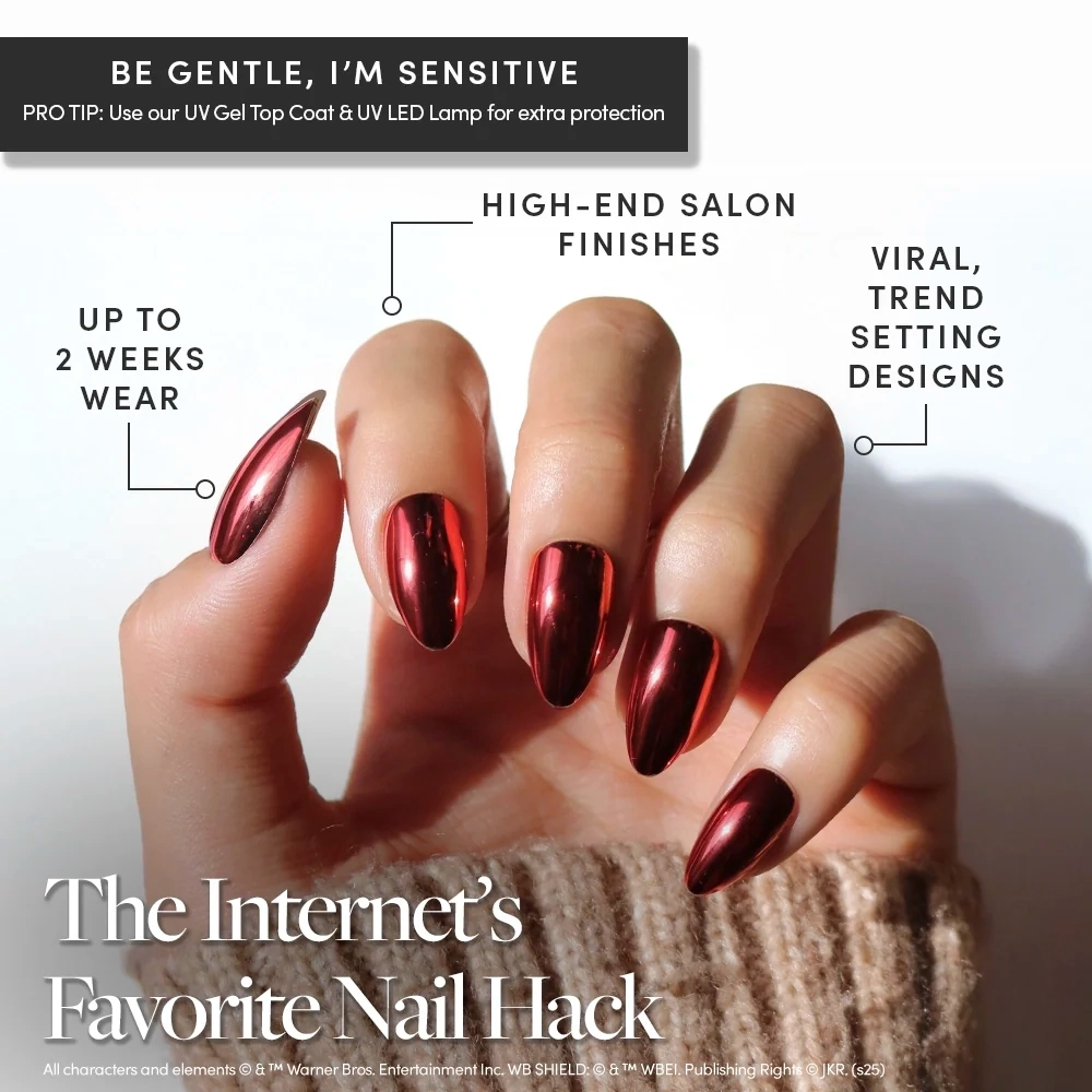A hand with long, shiny, dark red gel nails from the glamnetic Godric Gryffindor™ collection is held up, showcasing a glossy, salon-quality manicure with features like high-end finishes and on-trend designs. These press-on nails offer up to two weeks of flawless wear and capture the bold elegance inspired by Godric Gryffindor™. - Product image