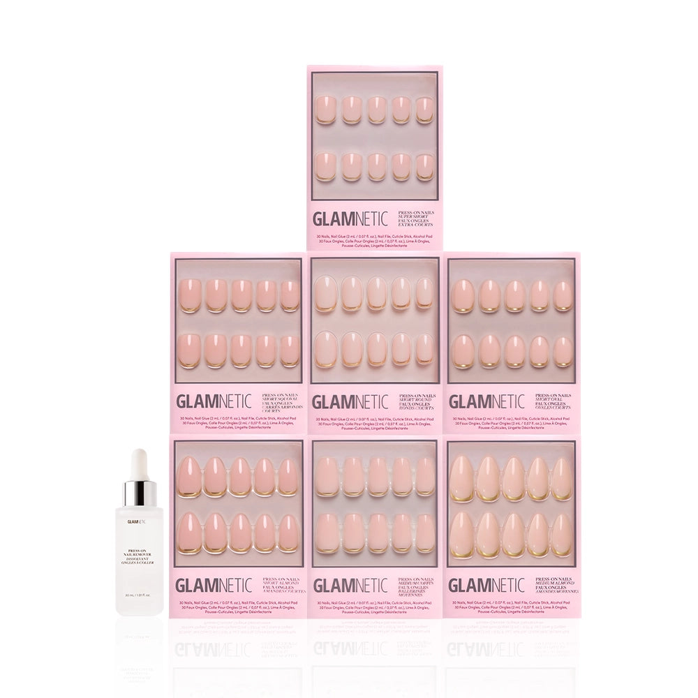 A pyramid of seven glamnetic Gold Girlie Bundle press-on nail boxes in light pink and nude French tips, with a dropper bottle of nail serum placed in front, all displayed on a white background. - Product image