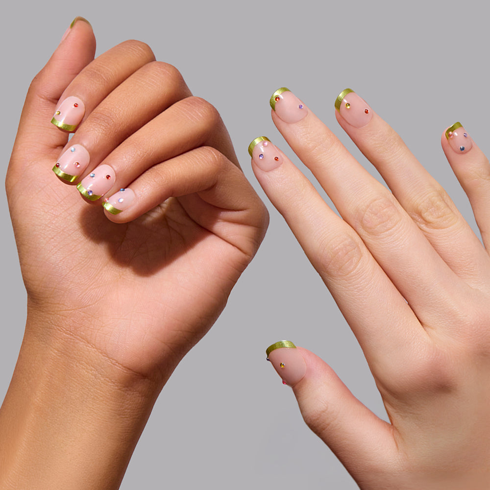 Goodie Gumdrops vegan press-on nails featuring a short, rounded shape with a nude base, metallic lime green chrome French tips, and multicolored rhinestone accents. - Product image