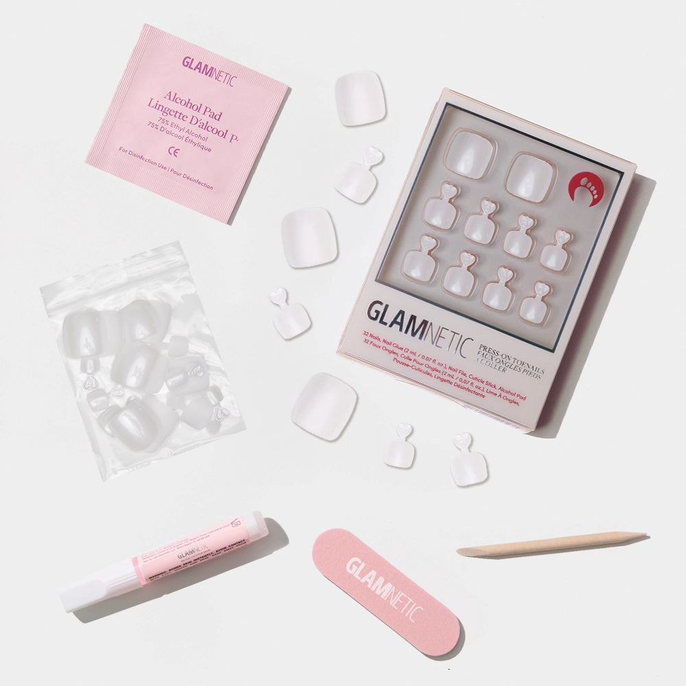 A flat-lay of the Glamnetic clean white press-on toenail kit with a glossy finish and included tools for application. - Product image