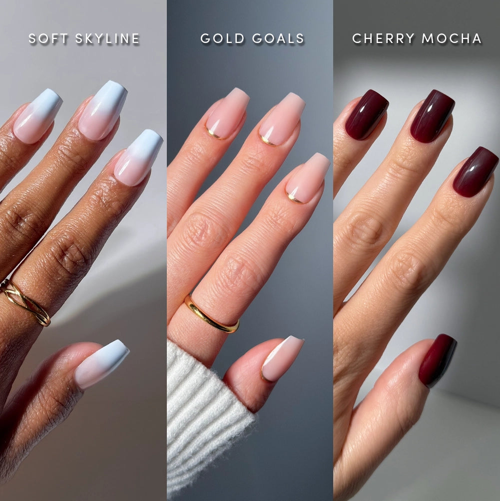 Three hands display distinct nail designs: the left showcases gradient blue and white nails, the center features glamnetic’s “Happy Mediums”—a nude medium coffin press-on nail set with gold tips—and the right presents deep cherry red salon-quality nails. Each hand wears minimal jewelry and is labeled with its respective nail style name. - Product image