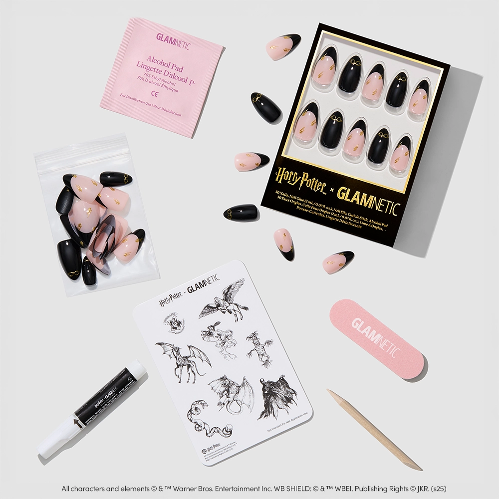 A flat lay of the glamnetic Harry Potter™ nail set, including almond press-on nails, black nail glue, a pink file, wooden cuticle stick, alcohol pad, magical creature tattoos, extra nails—all in a clear pouch. - Product image