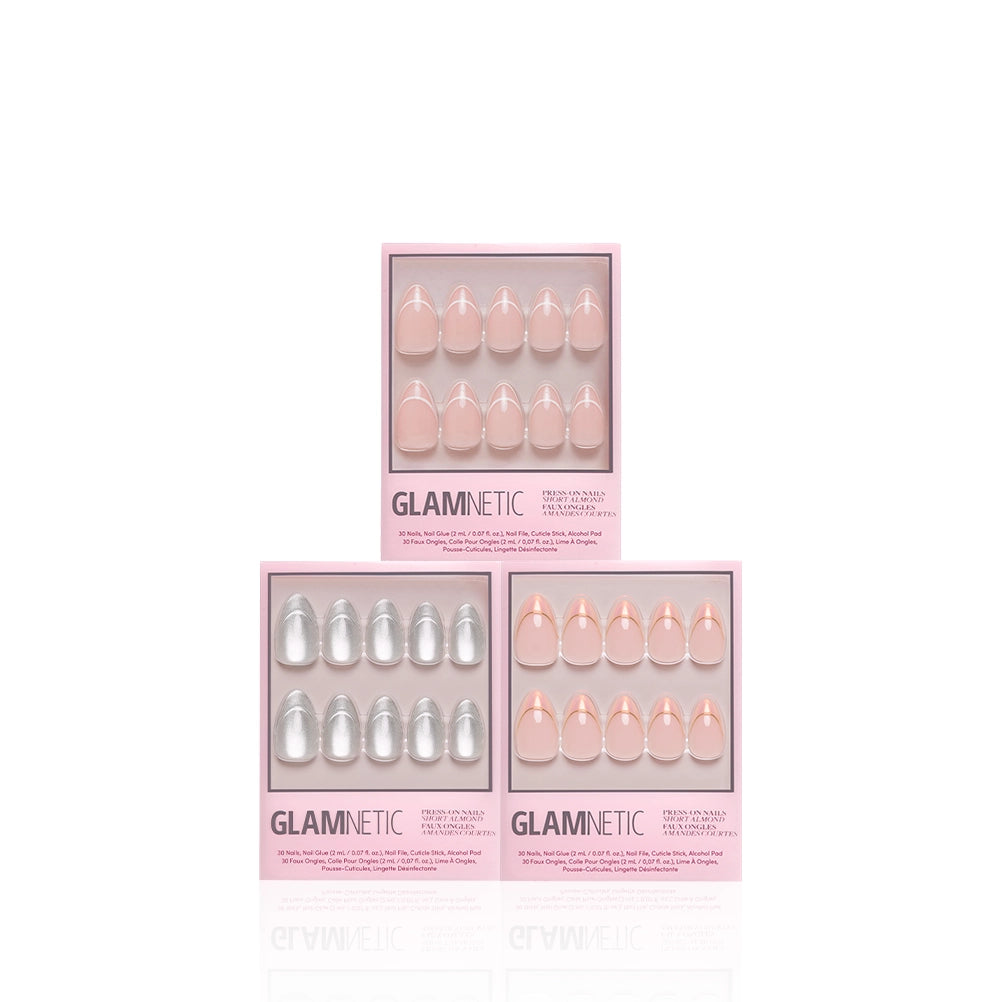 Three boxes of the glamnetic Heavenly Trio salon-quality press-on nails are displayed. Two sets feature light pink short almond nails, while the third set showcases silver nails. The boxes are arranged in a triangle on a white background. - Product image