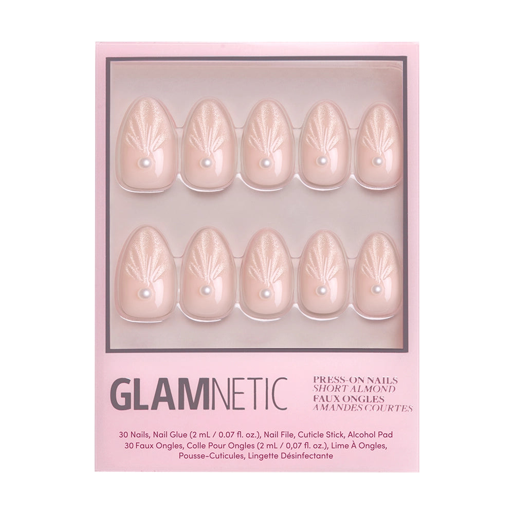 A box of glamnetic Honeymoon press-on nails in a short almond shape, featuring a nude pink shade with pearl accents and subtle leaf designs. Packaged in pink with product details at the bottom. - Product image