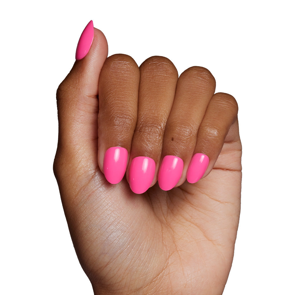 A hand with medium brown skin tone showcases glamnetic’s Hot Pink press-on nails in a short oval shape. The vibrant, well-manicured nails offer durable, long-lasting wear against a plain white background. - Product image
