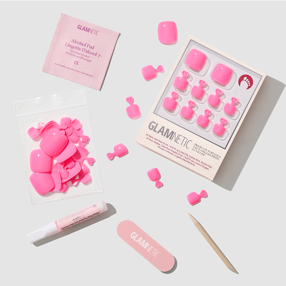 The glamnetic Hot Pink Toenail set features glossy press-on toenails and salon-grade accessories—alcohol pad, nail glue tube, nail file, cuticle stick, and extra nails—all neatly displayed on a white background. - Product image