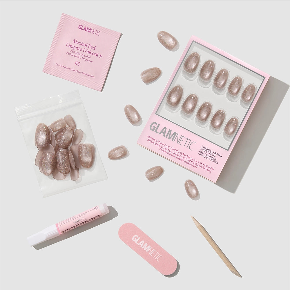 Introducing glamnetic’s Iced Latte Press-On Nail Kit, featuring glittery nude short oval nails, a pink nail file, cuticle stick, tube of glue, alcohol pad, and extra nails—all perfectly arranged on a light background. - Product image