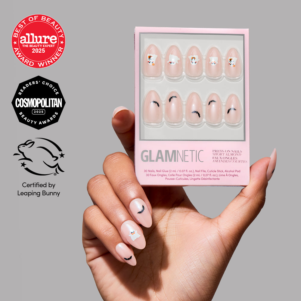 A hand with minimal nail art holds a box of glamnetic’s In The Spirit press-on nails, which feature a glazed finish for a chic touch. Award badges from Allure and Cosmopolitan, along with the Leaping Bunny cruelty-free certification, are displayed on the left side. - Product image