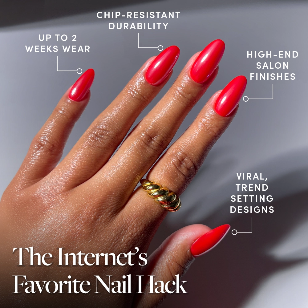 A hand with glossy, bright red It-Girl Red medium oval nails by glamnetic is shown, featuring chip-resistant durability, up to 2 weeks wear, salon-quality finish, and viral trend-setting designs. Gold rings adorn two fingers. - Product image