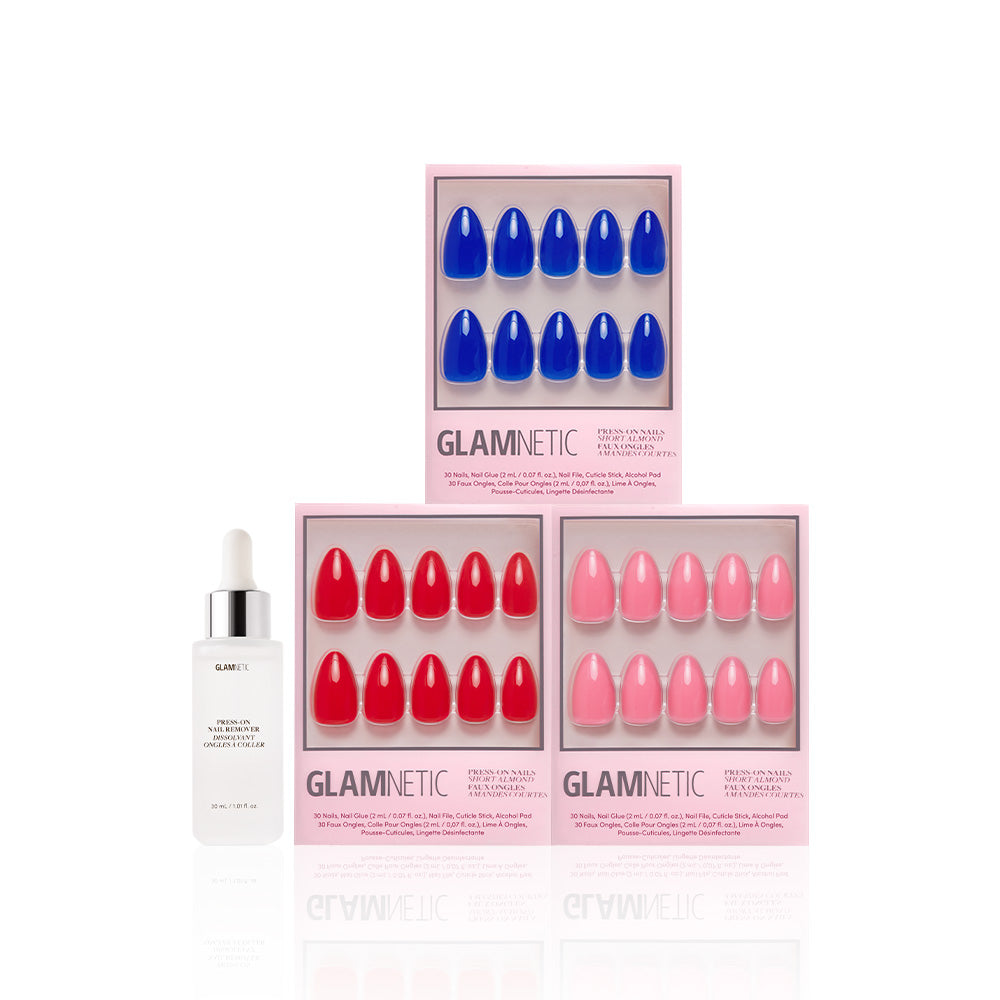 Three boxes of glamnetic It Girl Summer press-on nails, displayed in Flamingo Pink, Fiery Red, and Cobalt Blue shades, are arranged with a white dropper bottle of nail glue or serum on a white background. - Product image