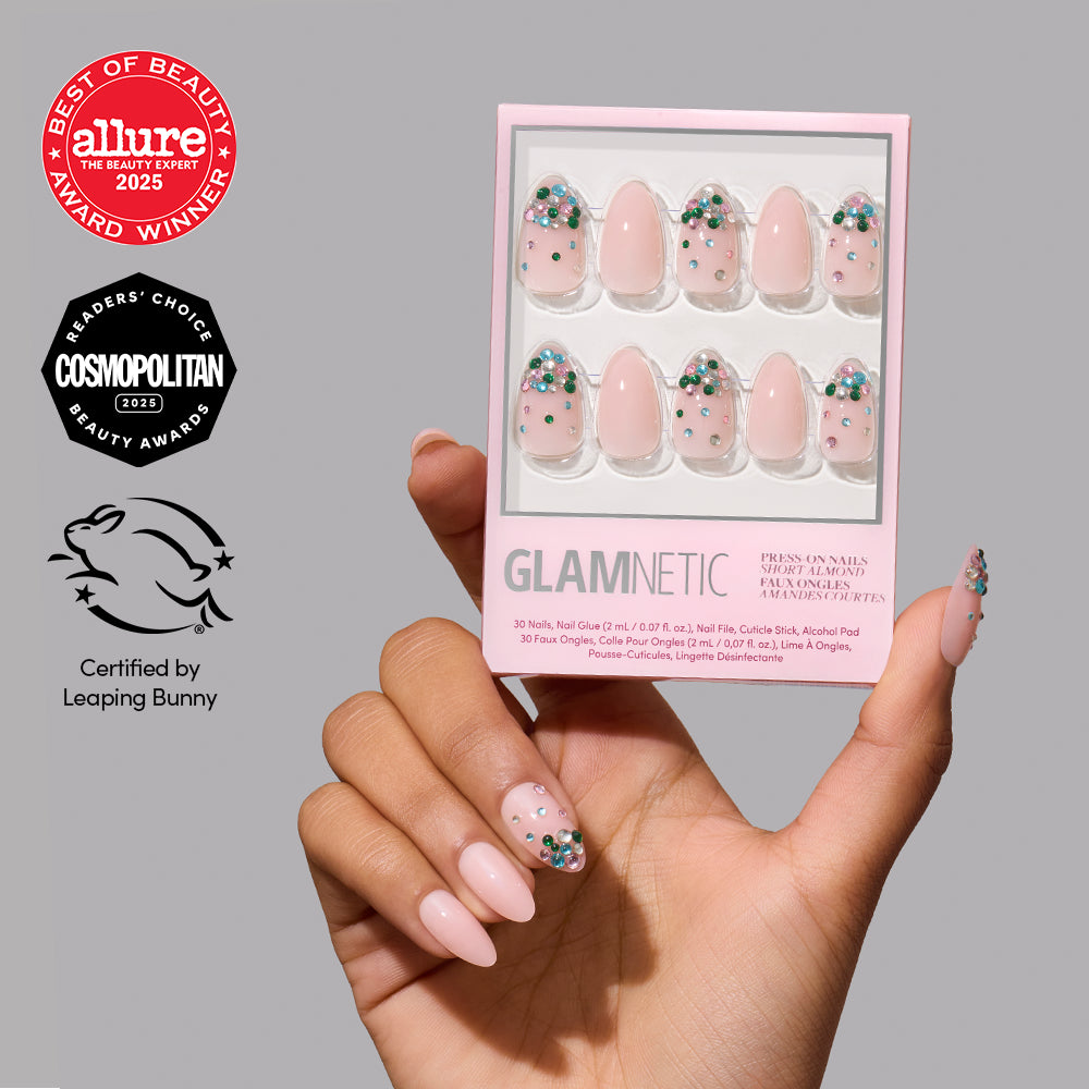 Jewel Thief - A hand holds a box of Glamnetic Jewel Thief short, almond-shaped press-on nails featuring a nude base with multicolored rhinestone accents, alongside Allure, Cosmopolitan, and Leaping Bunny award logos.