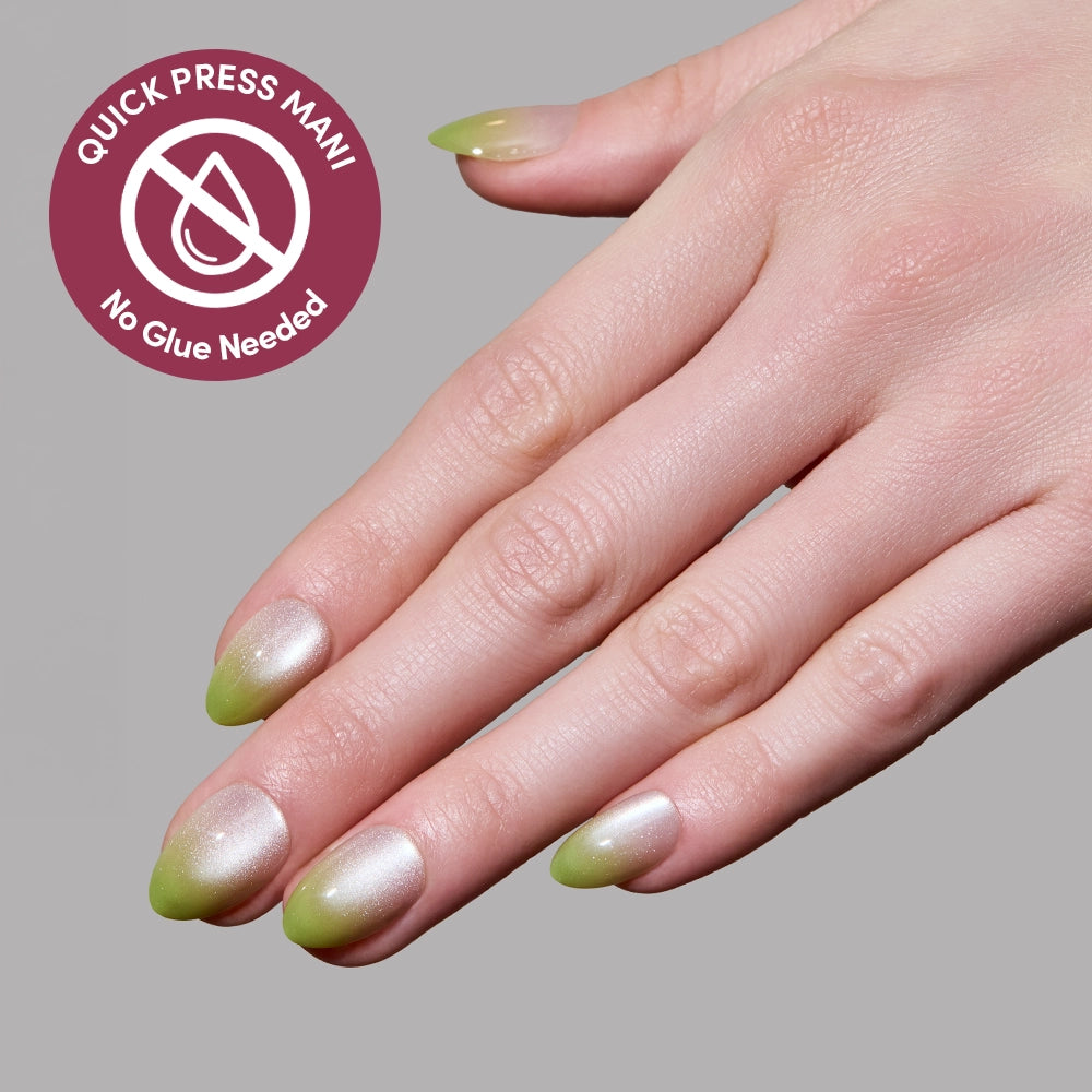 A hand with almond-shaped, green and pearly white ombré Lime Beam stick-on nails by glamnetic. A corner badge reads "Quick Press Mani, No Glue Needed" on a gray background. - Product image
