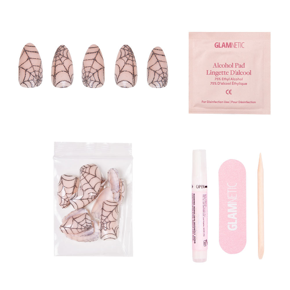 The glamnetic Lady Web set includes black sparkly spiderweb nails, alcohol pad, extra nails, nail glue, pink nail file, and cuticle stick—ideal for standout Halloween nails on a chic white base. - Product image
