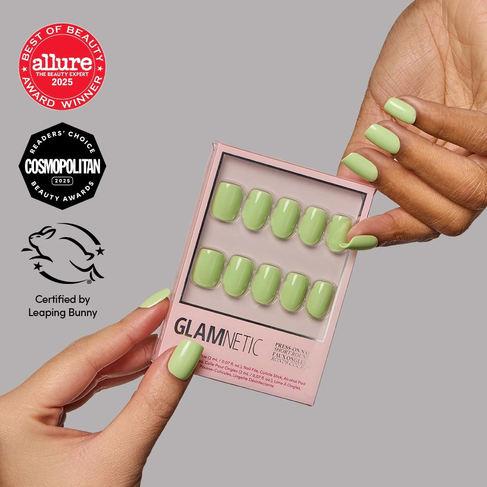 Light Sage - A hand with short, light sage green Glamnetic Light Sage press-on nails holds a matching replacement set in a pink box, accompanied by beauty award and vegan cruelty-free certification logos.