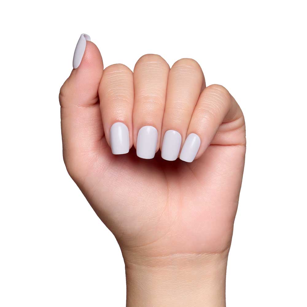 A hand with neatly manicured squoval nails painted in glamnetics Lilac Gray is shown against a white background. The slightly curled fingers highlight the pastel shade and glossy finish of these stylish nails. - Product image