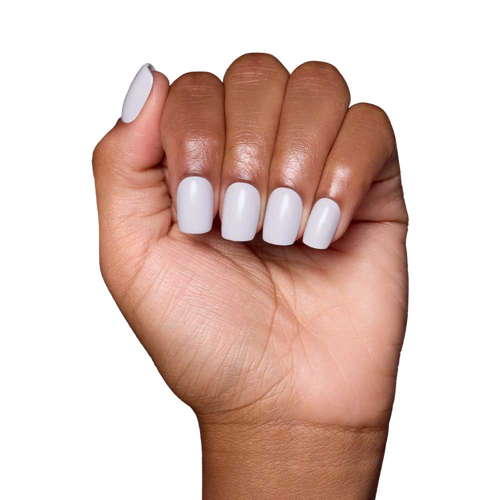 A medium brown-skinned hand forms a fist, showing squoval nails painted with glamnetic’s Lilac Gray polish in a glossy finish against a white background. - Product image